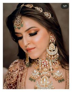 a woman in a bridal outfit with jewelry on her neck and headpieces