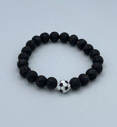 This piece is designed using 8mm lava beads and an 8mm enameled black and white soccer ball bead.  The contrast between the soccer ball and the lava is very striking and your soccer enthusiast will just love it. A great bracelet for all of your soccer fans and players!   This bracelet is offered in assorted sizes.  If you do not see the size you are looking for please contact me. Football Fan Accessories, Bracelets For Boys, Soccer Bracelet, Soccer Jewelry, Dad Bracelet, Football Jewelry, Business Jewelry, Football Bracelet, Poughkeepsie Ny