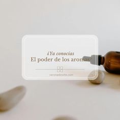 a brown bottle sitting on top of a table next to two spoons and a white sign