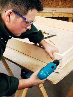 a man using a power drill on a piece of wood