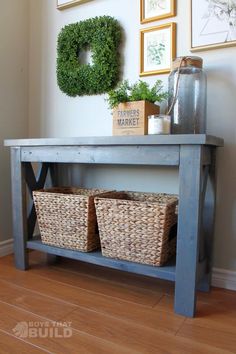 a wooden table with baskets under it and pictures on the wall