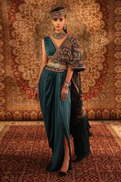 Teal woven satin pre-draped saree with attached pallu all over embroidered in jamawar pattern kashida work, ruffle, tasselled border and pleated cowl drapes. Paired with deep V neck blouse with embroidered borders and handcrafted belt.
Components: 3
Pattern: Woven and Embroidered
Type Of Work: Jamawar Pattern, Kashida Work and Feather Tassels
Neckline: Deep V Neck
Sleeve Type: Sleeveless
Fabric: Satin, Blouse Lining: Shantoon, Saree Lining: Lycra
Color: Green,Blue
Other Details: 
Embroidered and Aditi Gupta, Royalty Aesthetic, Embellished Belt, Drape Saree, Green Saree, Blouse For Women, Blouse Online, Saree With Blouse, Green Satin