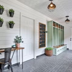 a room with several potted plants on the wall and two desks in front of them