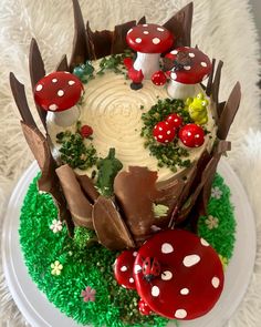 a cake decorated with mushrooms and grass on a plate in the shape of a forest