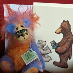 two stuffed bears are next to a book with an image of a bear on it