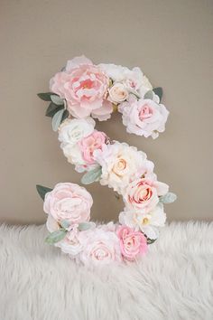 the letter s is made up of flowers and leaves on a white furnishing