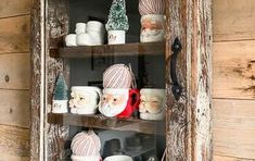 an old wooden shelf filled with mugs and christmas decorations