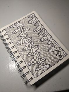 a notebook with an intricate design on the front and back cover is sitting on a table