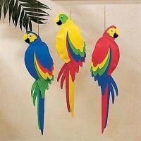 three colorful parrots hanging from strings in front of a palm tree and white wall