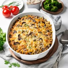 a casserole dish with cheese, mushrooms and broccoli on the side