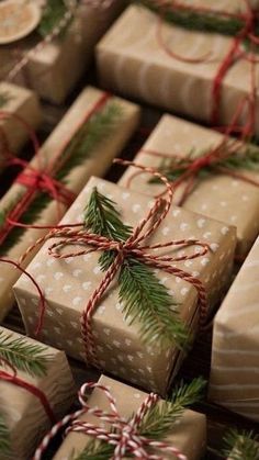 many wrapped presents with bows and pine needles