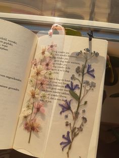 an open book with flowers on the pages