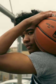 a young man holding a basketball over his head