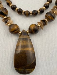 This is a stunning Tiger's Eye Necklace which can be a single strand 23 1/2 inches or make it a double strand measuring 18 1/2 inches. They are accented by gold spacers and beads.  Ideally they should be worn together for greater impact.  But the combo offers a simple look given the right opportunity. Brown Agate Gemstone Beaded Necklace, Brown Agate Necklaces With Polished Beads, Multi-strand Agate Beaded Necklaces, Tigers Eye Beaded Necklace, Tigers Eye Pendant, Tigers Eye Necklace, Double Strand Necklace, Pretty Jewelry, Tiger's Eye