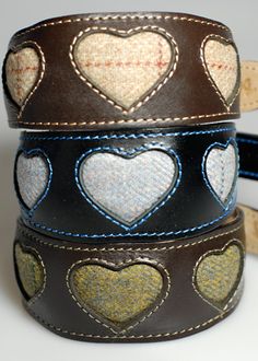 three leather bracelets with hearts on them