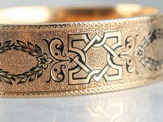 "This antique bracelet is in excellent condition, with very little wear to the beautiful gold. The black enamel pattern and fine engraving on the top are intricate and in great condition! The inside of the bangle has the original monogram, the name of the owner in a beautiful French script. The polish is soft and creates a lovely texture on the wrist. Metal: 14K Antique Rose Gold Material: Black Enamel Width: 19 mm Inside Circumference: 6 Inches Marks: \"CARRIE G. LECMAN\" Engraved SKU #: 2PX2UL Fun Antique Gold Engraved Bangle Bracelet, Engraved Antique Gold Bangle Bracelet, Vintage Black Enamel Bracelets For Formal Occasion, Ornate Engraved Gold Bangle Bracelet, Vintage Engraved Rose Gold Bracelet, Vintage Rose Gold Engraved Bracelet, Antique Black Bangle Jewelry, Victorian Engraved Gold Bracelet For Ceremonial Occasions, Antique Bracelets With Decorative Band As Gift