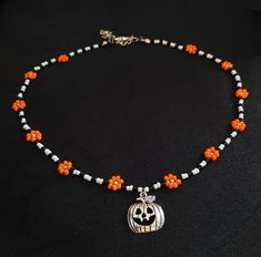 an orange and white beaded necklace with a pumpkin