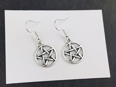 "Pentacle Earrings Silver tone Pentacle charms featured on earring hooks of your choice (silver plated or sterling silver).   Check out our Witchy range here: https://www.etsy.com/shop/craftchemygiftshop/?etsrc=sdt&search_query=witch Size:  Charms: 17x17mm (approx. 3/4 x 3/4'') Total length: 4 cm (approx. 1 1/2\") Materials: Charms: zinc alloy Earring hooks: - silver plated Or - sterling silver PACKAGING Each item comes on white backing card inside a cellophane bag (unless requested or specified otherwise, e.g. gift wrap). All our items are shipped in a bubble mailer. If you something extra, check out our gift wrap option:   https://www.etsy.com/uk/listing/904606552/add-gift-box-craftchemy-gift-shop-gift?ref=shop_home_active_3&pro=1&frs=1 SHIPPING We aim to ship all orders within 3 working Pentacle Earrings, Wiccan Earrings, Witchcraft Jewelry, Silver Packaging, Witch Earrings, Gothic Witch, Jewelry Gothic, Goth Jewelry, Witch Costume