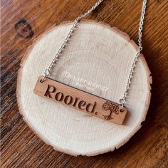 a wooden necklace with the word rooted engraved on it