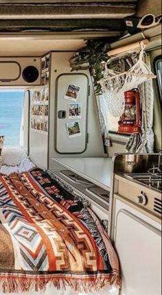 a bedroom with a bed, refrigerator and sink inside of an rv at the beach