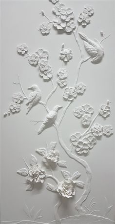 a white wall with flowers and birds on it