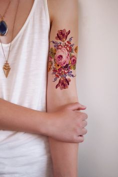 a woman with a flower tattoo on her arm