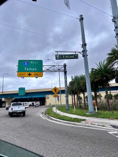 cars are driving down the street in front of a west tampa sign