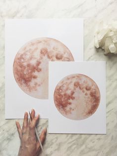 two pictures of the same moon on paper and one is being drawn with a pencil