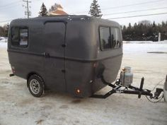 an rv parked in the snow next to a trailer