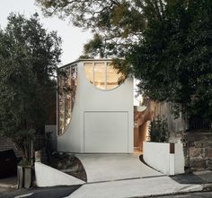 the house is surrounded by trees and has a circular window on it's side