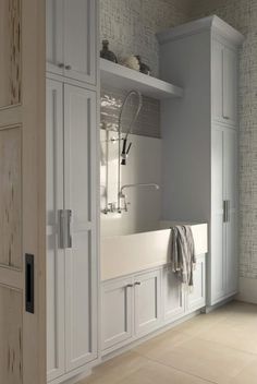 a white kitchen sink sitting under a window next to cupboards and cabinets in a room