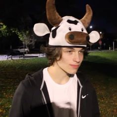 a young man wearing a cow hat at night