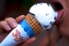 a close up of a person eating an ice cream cone