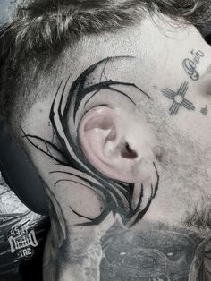 a man with tattoos on his face and neck