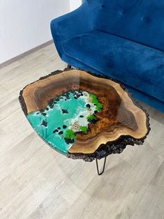 a blue couch sitting next to a wooden table on top of a hard wood floor