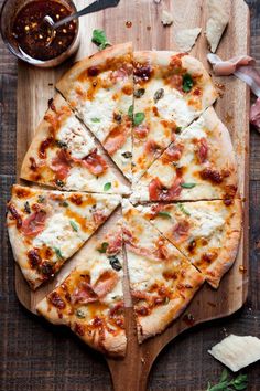 a sliced pizza sitting on top of a wooden cutting board