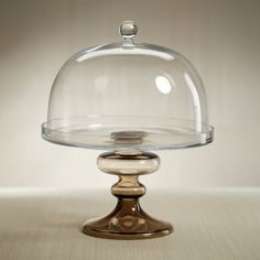 a glass cake plate with a domed cover on top