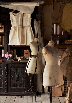 two mannequins are standing next to each other in front of a wooden cabinet