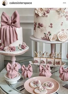 a table topped with lots of different cakes and desserts covered in pink bows on top of each cake