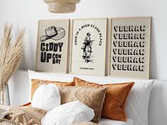 two posters on the wall above a bed in a room with white walls and pillows