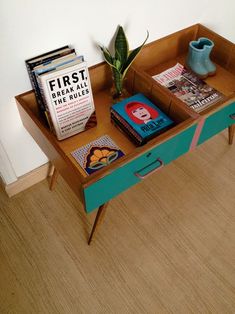 a wooden table topped with books and a plant