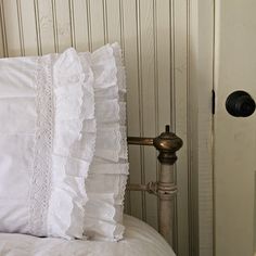 a white pillow sitting on top of a bed next to a door