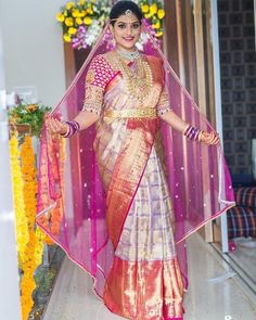 a woman in a pink and gold sari