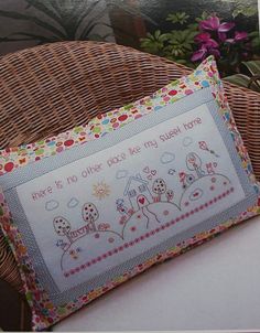 a pillow sitting on top of a chair next to a basket with flowers in it