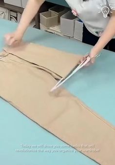 a person cutting fabric with scissors on a table