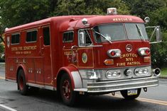 an old fire truck is driving down the street