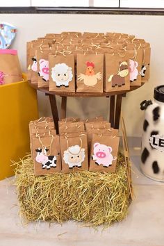 some brown bags with farm animals on them sitting in hay next to a cow vase