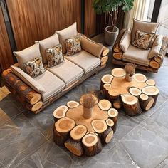 a living room filled with lots of furniture and wood pieces on the floor next to a plant