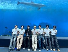 the boys are posing in front of an aquarium