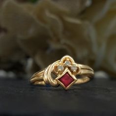 Vintage ruby and diamond ring from the 1980s designed in an Art Deco revival.  Stones: Princess cut ruby and round cut diamonds Metal: 14k yellow gold Ring Size: 6.5 but can be resized by a jeweler Time Period: 1980s  Free shipping in the USA. Vintage Yellow Gold Ruby Birthstone Ring, Vintage Yellow Gold Ruby Ring Birthstone, Vintage Gold Ruby Ring With Birthstone, Vintage Gold Ruby Birthstone Ring, Gold Ruby Ring Vintage Birthstone, Vintage Style Red Cluster Ring In 14k Gold, Antique Gold Ruby Ring With Diamonds, Vintage Red Ruby Ring For Anniversary, Vintage Red Ruby Ring Stamped 14k